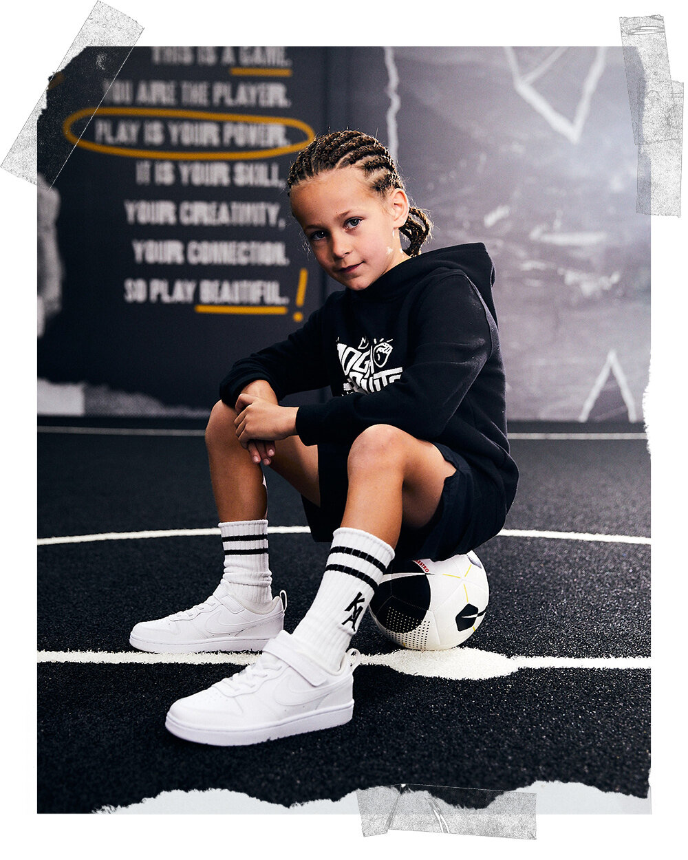 A+boy+sitting+on+a+soccer+ball+on+an+indoor+soccer+pitch